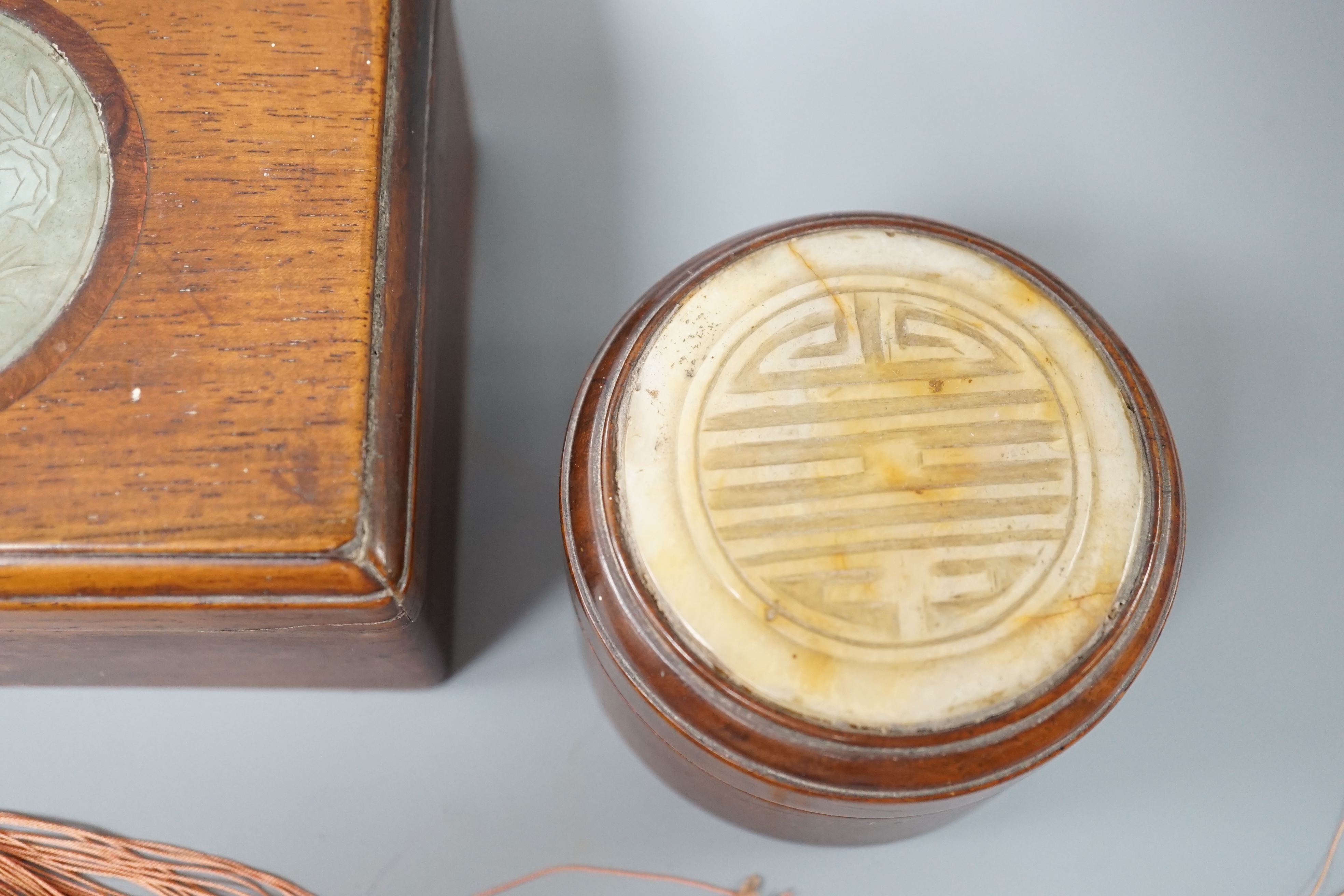 Two 19th century Chinese hardstone inset hardwood boxes and an embroidered amulet charm, largest box 12.5cm